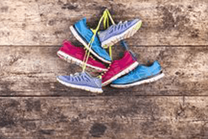graphicstock-three-pairs-of-running-shoes-hang-on-a-nail-on-a-wooden-fence-background-300x